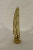 A fine Japanese Meiji Period carved ivory okimono as a fisherman mending his net hanging upon a