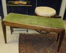 A mahogany duet stool with green velvet upholstery, raised on square tapering legs,