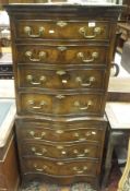 A walnut serpentine fronted chest on chest of small proportions with dentil cornice above four