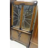 An early 20th Century oak display cabinet with leaded glazed doors above two enclosed doors below,