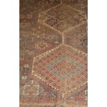 A Caucasian rug, the two central medallions in terracotta, blue and cream, on a blue,