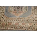 A Persian rug, the central medallion in taupe, salmon, cream and black, on a silver grey ground,