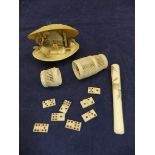 A carved bone cricket cage containing various bone dominoes,