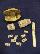 A carved bone cricket cage containing various bone dominoes,