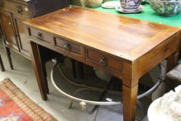 A modern hardwood side table, the plain top above three drawers,