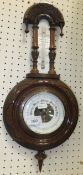 A circa 1900 aneroid barometer thermometer in carved Gothic style frame