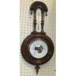 A circa 1900 aneroid barometer thermometer in carved Gothic style frame