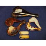 Two Meerschaum pipes, one in the form of a hand,