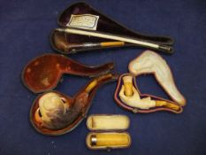 Two Meerschaum pipes, one in the form of a hand,