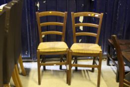 A set of eight beech framed bar back dining chairs with rush seats