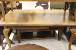A circa 1900 oak rounded rectangular dining table on cabriole legs to pad feet and castors