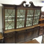 A Portugese mahogany breakfront display cabinet with swan neck moulded pediment over four astragal