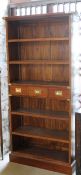 A modern mahogany six shelf open bookcase and three short drawers with campaign style handles,