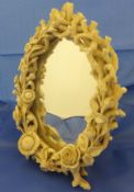 A Belleek porcelain oval easel mirror with applied floral and coral decoration with easel back