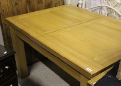 A modern rectangular light oak draw leaf dining table on square supports (TO BE SOLD WITH THE