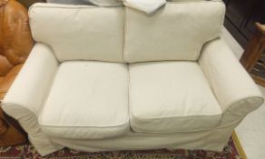 A modern OKA cream two seater sofa and a cream headboard