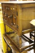 An oak two-door cupboard with carved panelled doors to turned legs united by stretchers,