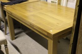 A modern rectangular light oak draw leaf dining table on square supports (TO BE SOLD WITH THE