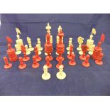 A 19th Century carved bone and red-stained bone chess set with two spare white pawns