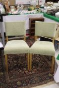 A set of four modern kitchen chairs with green upholstered seats and backs,