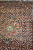 A Caucasian rug, the central floral decorated medallion in blue, terracotta, gold, cream and green,