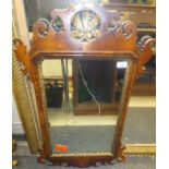 A walnut fretwork carved wall mirror in the early 18th Century manner