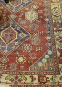 A Caucasian rug with repeating lozenge shaped medallions on a red ground,