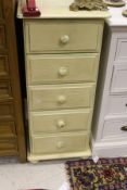 A modern cream painted narrow chest of five drawers with turned knob handles