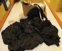 A box containing assorted 19th Century clothing to include a black beaded shawl, a mourning dress,