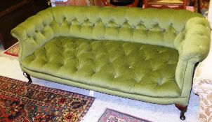 An Edwardian upholstered and button decorated green velvet sofa