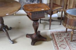 A 19th Century rosewood sewing table, the shaped top opening to reveal a fitted interior,