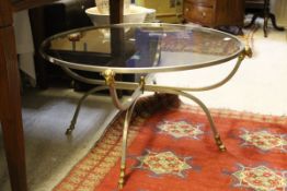 A early 20th century chromed and gilt framed circular glass topped table with rams head and rams