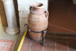 A Greek terracotta amphora with two ribbed bands united by the side handles over a plain body,