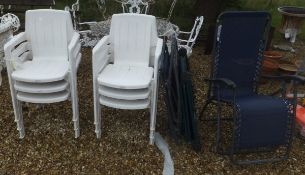 A set of six white plastic garden chairs and three folding deck chairs