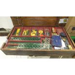 A wooden box containing an assortment of vintage Meccano