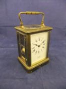 A circa 1900 French lacquered brass cased carriage timepiece with visible escapement and repeat,
