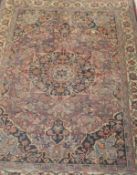 A Persian rug with flower head central medallion and all-over floral and foliate decoration on a
