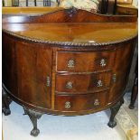 An early 20th Century mahogany bow fronted side cabinet with three drawers flanked by two cupboard