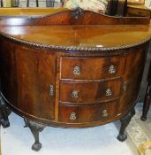 An early 20th Century mahogany bow fronted side cabinet with three drawers flanked by two cupboard