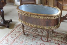 A walnut and brass decorated oval wine cooler in the Louis XVI manner