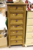 A modern pine narrow chest of seven drawers