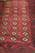 An Iranian rug, the centre field with repeating pattern in maroon, cream, black and beige,