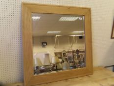 An oak framed square wall mirror