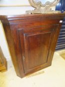 An early 19th Century oak hanging corner cupboard,