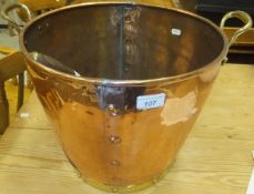A copper and brass coal bucket with shovel