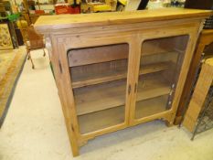 A pine two door display cabinet enclosing four shelves