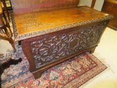 A 20th Century carved walnut coffer in the Art Nouveau style with carved scrolling foliate and