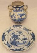 An 18th Century Delft plate decorated in underglaze blue with stylised flowers and rocks,