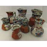 A collection of five ironstone red scale hydra jugs,