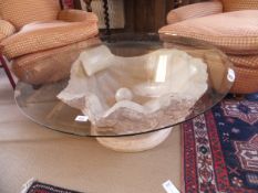 A composite stone coffee table in the form of an oyster shell with pearl,